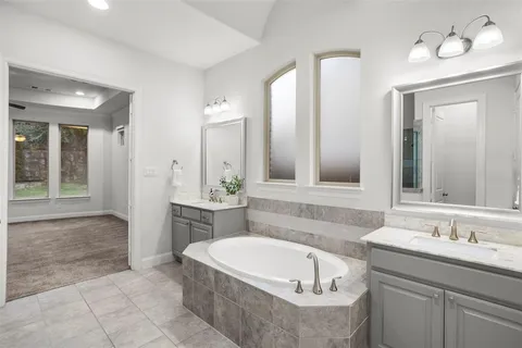 a bathroom with a tub sink and mirror