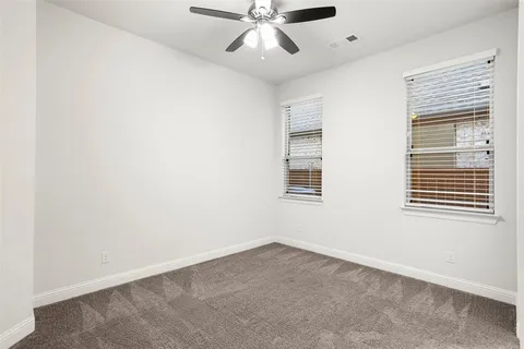 an empty room with a window and a ceiling fan