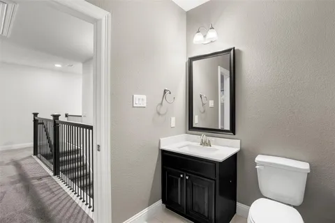a bathroom with a toilet sink and mirror