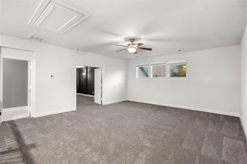 a view of an empty room with a ceiling fan
