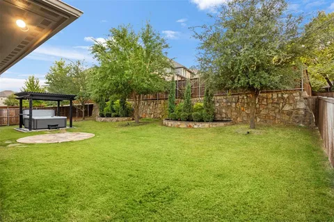 a view of a backyard with plants and large trees