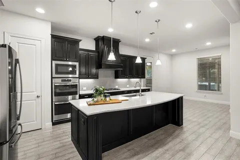 a kitchen with stainless steel appliances a sink stove and refrigerator