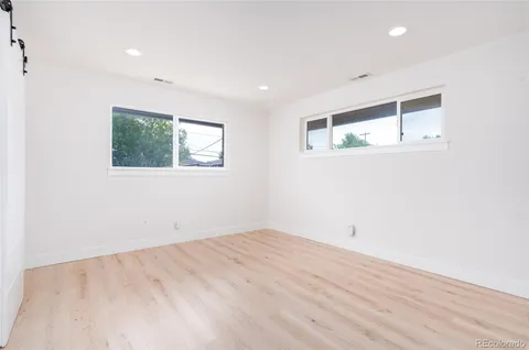 an empty room with wooden floor and window