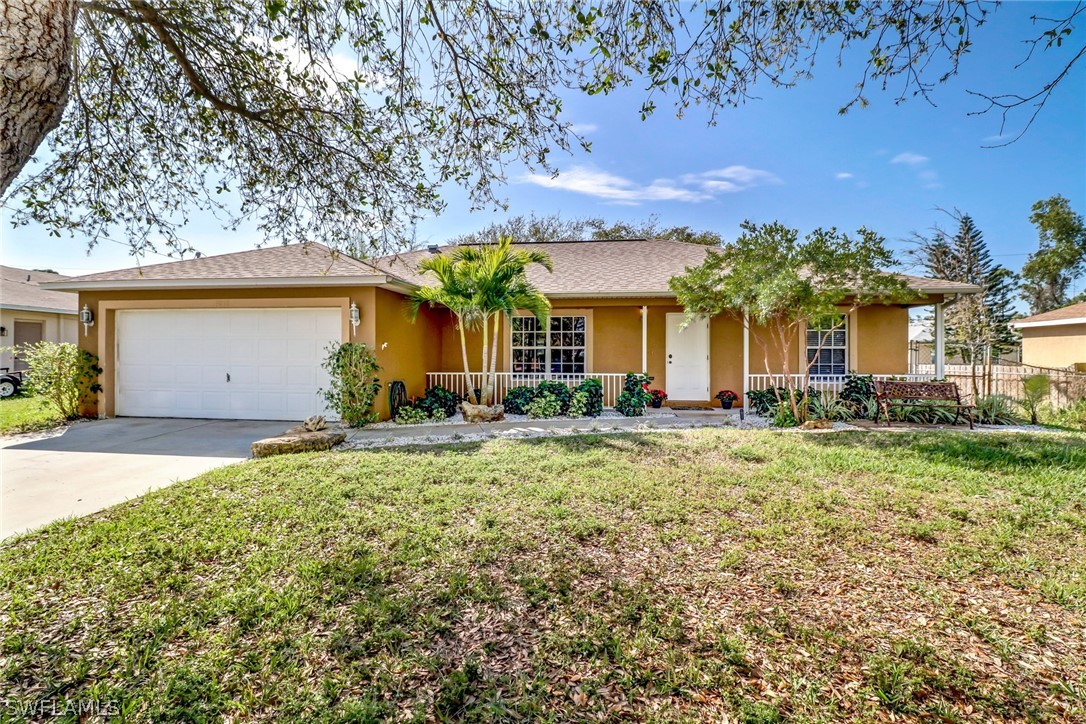 9050 Henry Road Fort Myers, FL 33967 - Photo 1 of 16 front view of house with a yard and potted plants