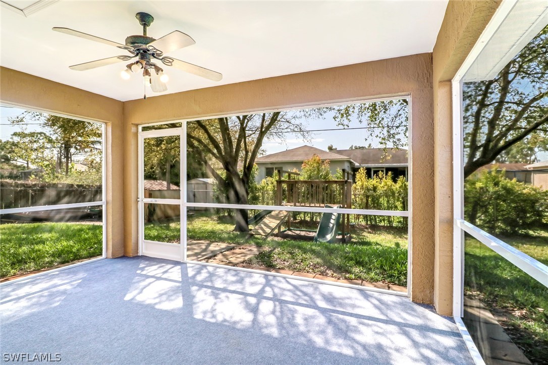 9050 Henry Road Fort Myers, FL 33967 - Photo 15 of 16 a porch with a table and chairs under an umbrella