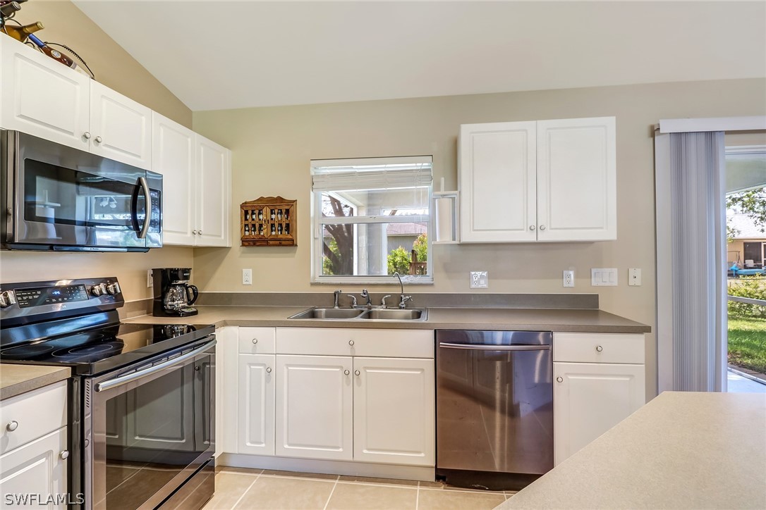 9050 Henry Road Fort Myers, FL 33967 - Photo 8 of 16 a kitchen with granite countertop white cabinets and white appliances