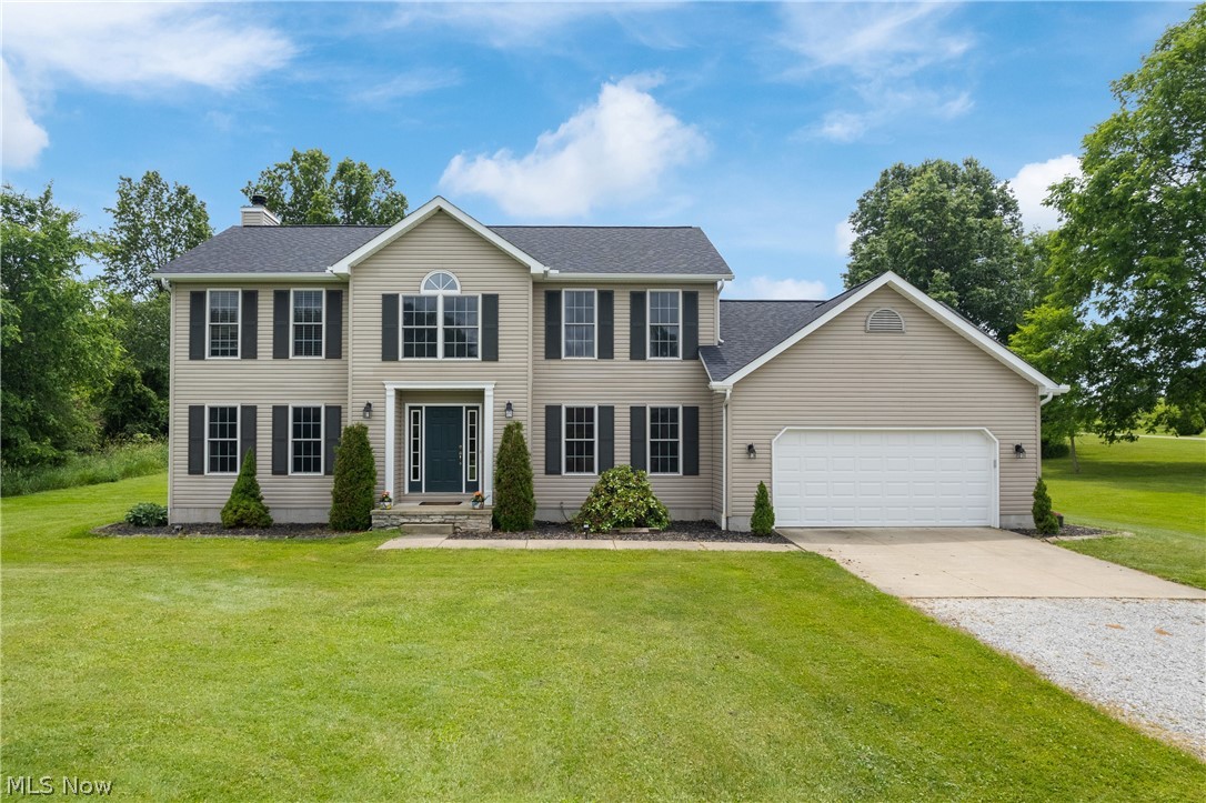 Two-story residence with light-colored siding and dark shutters