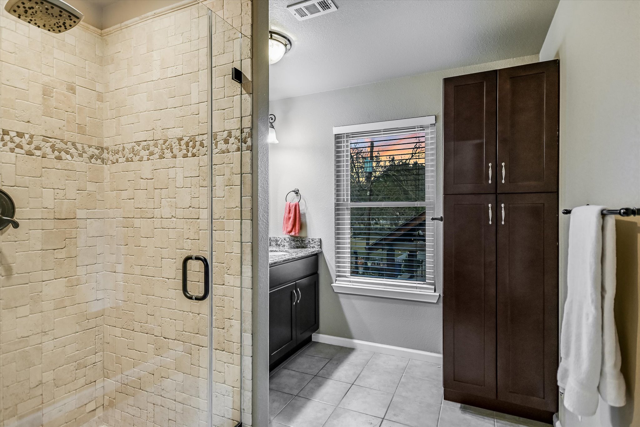 1801 Sun Lake Round Rock, TX 78681 - Photo 21 of 31 En-suite bathroom for bedroom 4. Gorgeous travertine shower with frameless glass, bountiful linen storage, and a vanity with granite countertop
