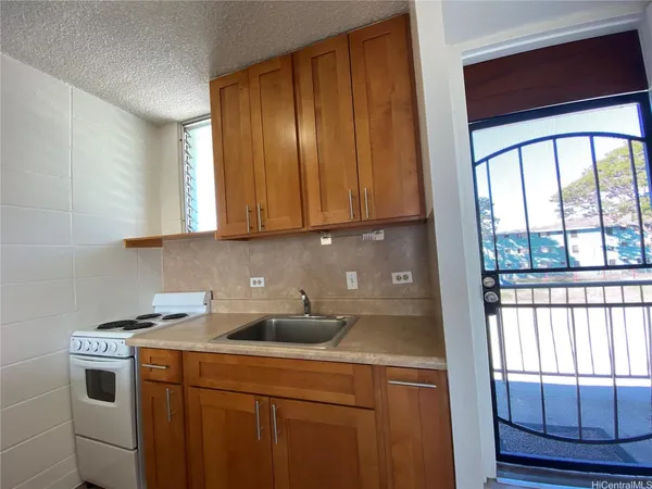 a kitchen with a stove a sink and a window