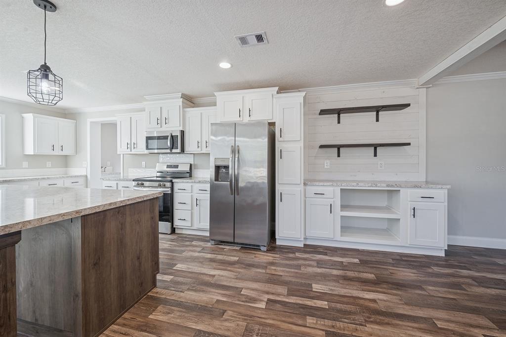 19750 Southeast 30th Street Morriston, FL 32668 - Photo 25 of 52 a kitchen with stainless steel appliances a refrigerator sink and cabinets