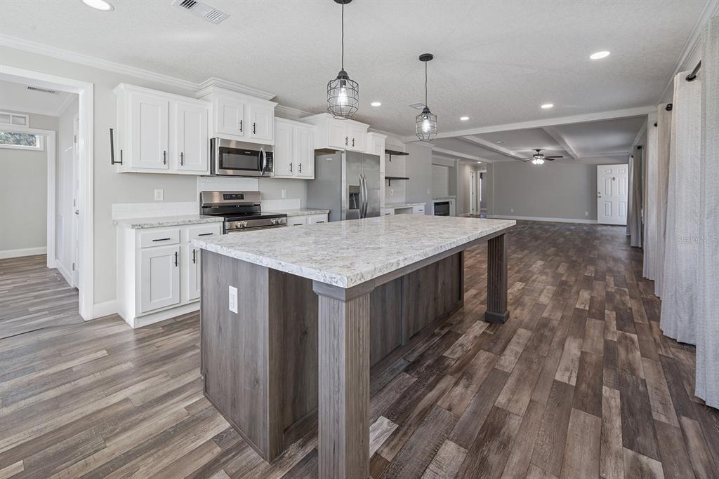 19750 Southeast 30th Street Morriston, FL 32668 - Photo 30 of 52 a kitchen with kitchen island a sink counter top space stainless steel appliances and a window