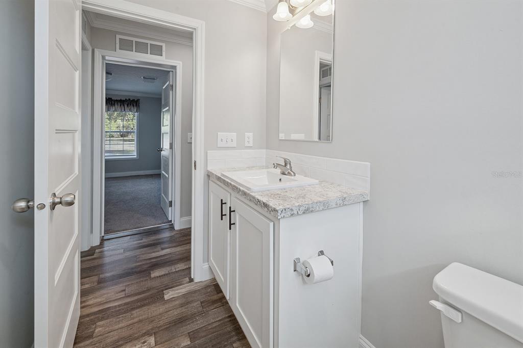 19750 Southeast 30th Street Morriston, FL 32668 - Photo 52 of 52 a bathroom with a granite countertop sink and a toilet