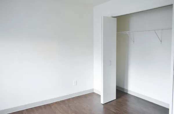 a view of an empty room with wooden floor