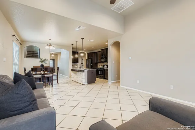 a living room with furniture and kitchen view