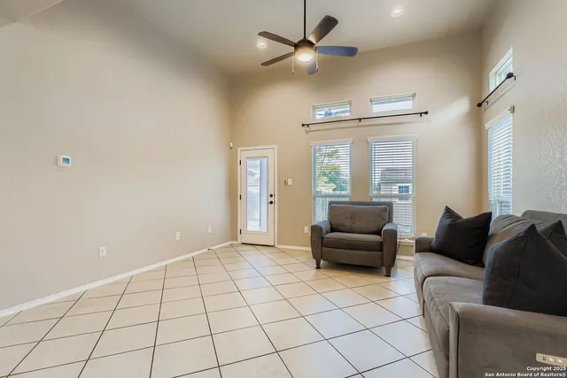 a living room with furniture and a ceiling fan