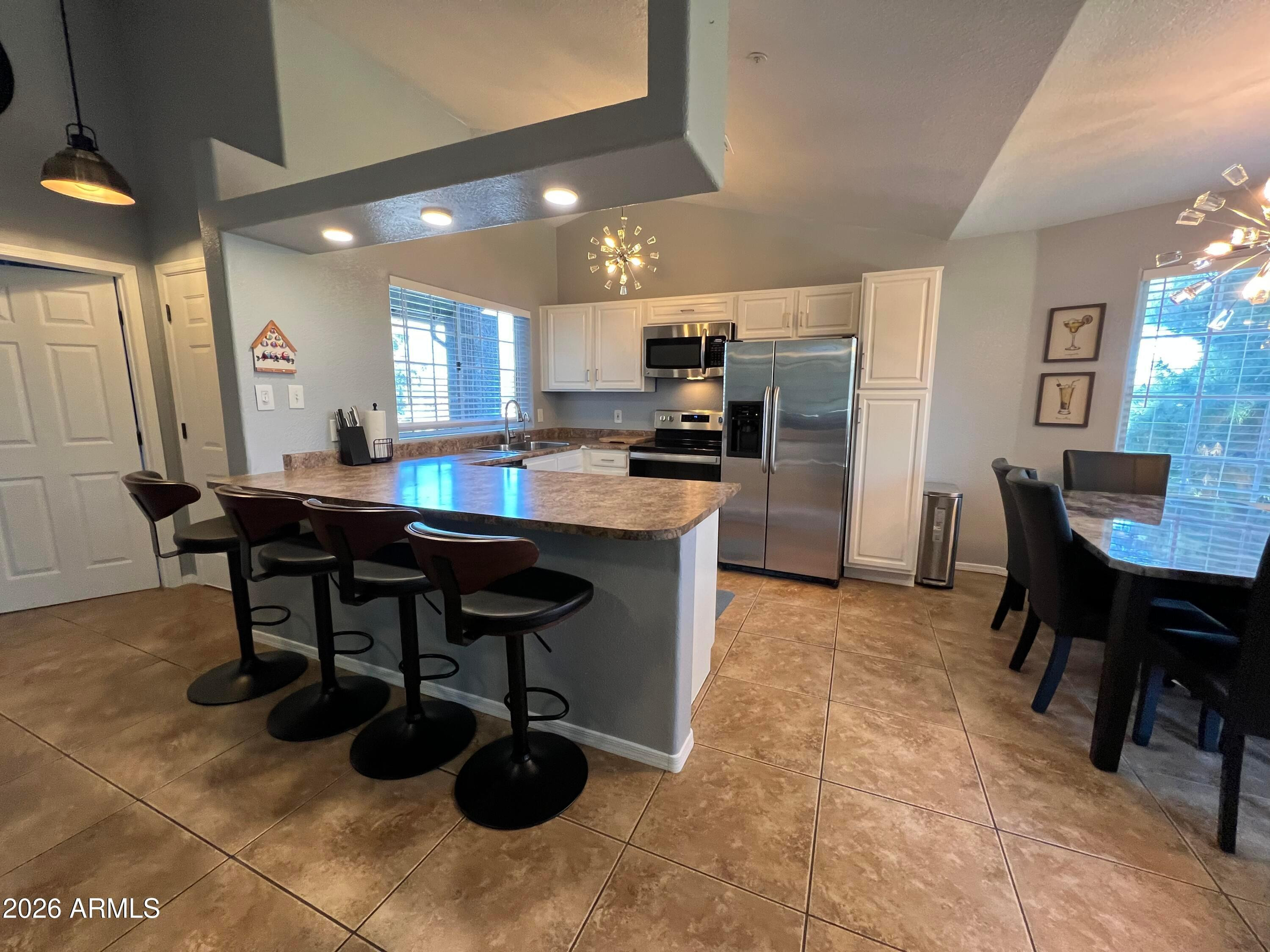 a kitchen with a table chairs and a refrigerator
