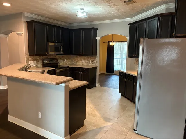 a kitchen with stainless steel appliances a refrigerator stove and microwave