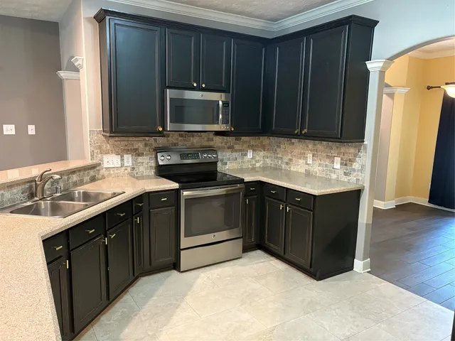 a kitchen with a sink stove and microwave