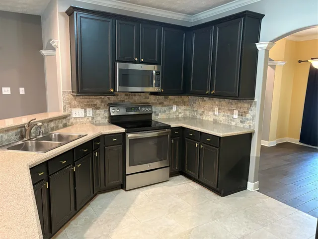a kitchen with a sink stove and microwave