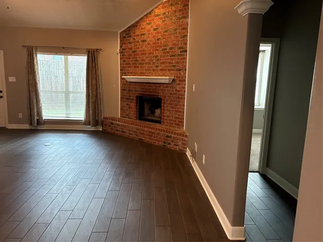 wooden floor in an empty room with a fireplace