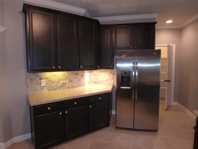a kitchen with granite countertop stainless steel appliances cabinets and a window