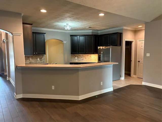 a kitchen with stainless steel appliances granite countertop a refrigerator a sink and a stove