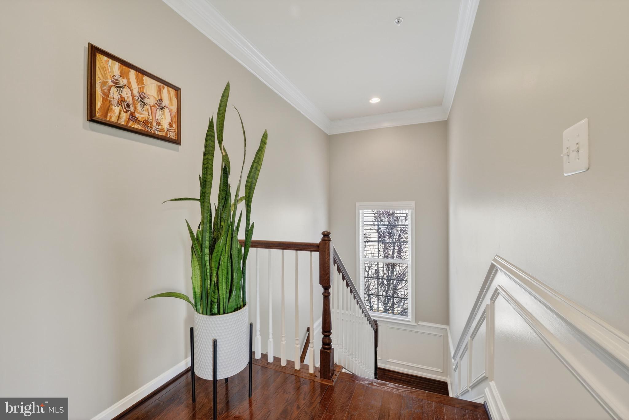 9205 Rice Avenue Lanham, MD 20706 - Photo 23 of 68 a view of a hallway with wooden floor and stairs