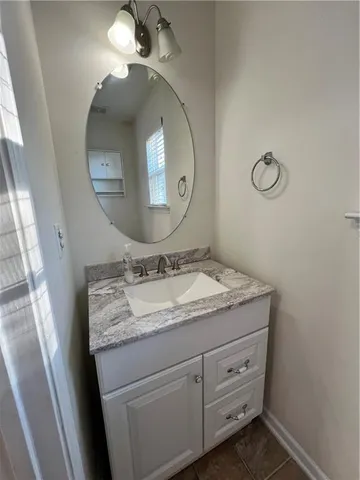 a bathroom with a granite countertop sink a mirror and vanity