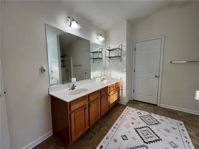 a bathroom with a sink a mirror and a shower