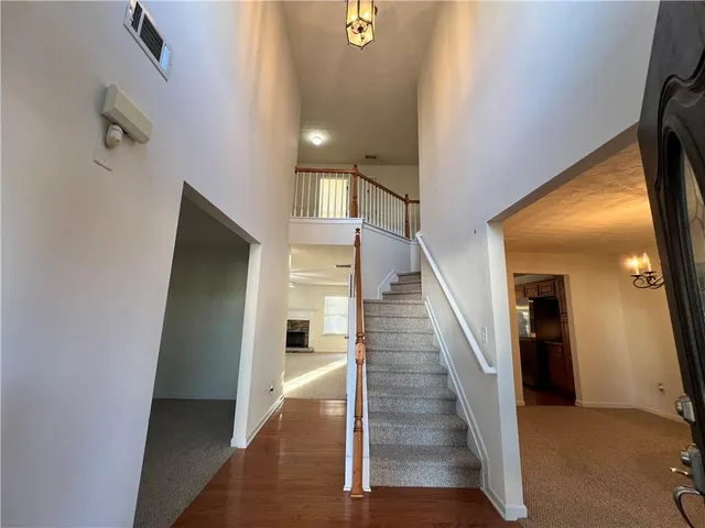 a view of a hallway with wooden floor and staircase