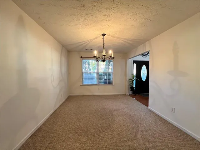 an empty room with windows and chandelier