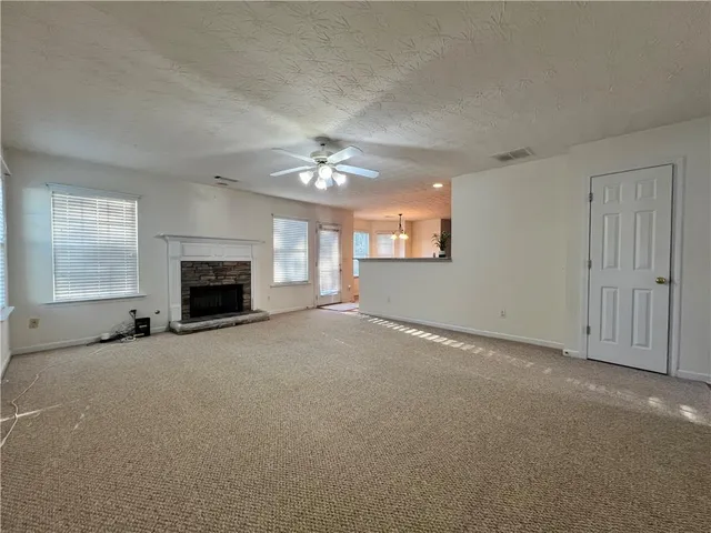 an empty room with windows and fireplace