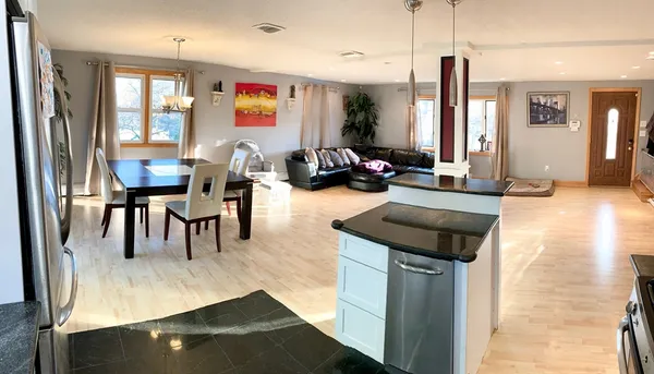 a living room with furniture a rug and kitchen view