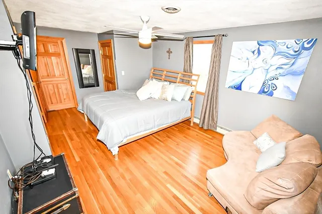 a bedroom with a bed and wooden floor