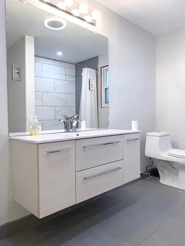 a bathroom with a toilet sink and mirror