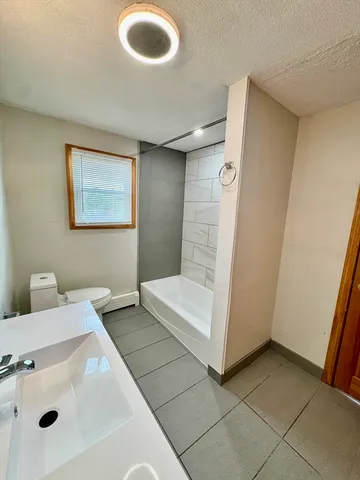 a bathroom with a tub sink a mirror and shower