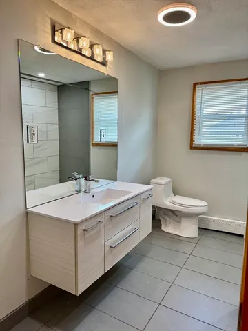a bathroom with a sink a toilet and mirror