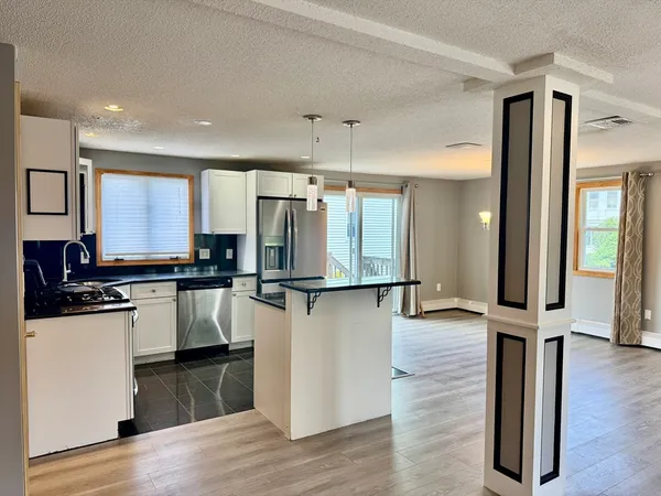 a kitchen with stainless steel appliances a refrigerator and wooden floor
