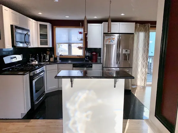 a kitchen with stainless steel appliances granite countertop a refrigerator and a stove top oven