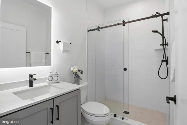 a bathroom with a sink toilet vanity and shower