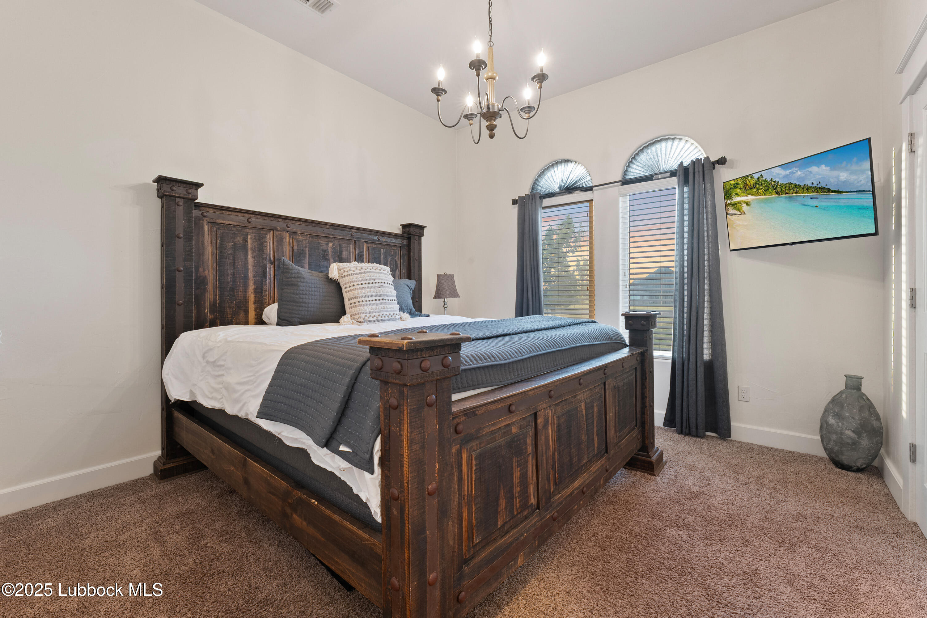5125 County Road 7930 Lubbock, TX 79424 - Photo 38 of 75 a spacious bedroom with a bed and a chandelier