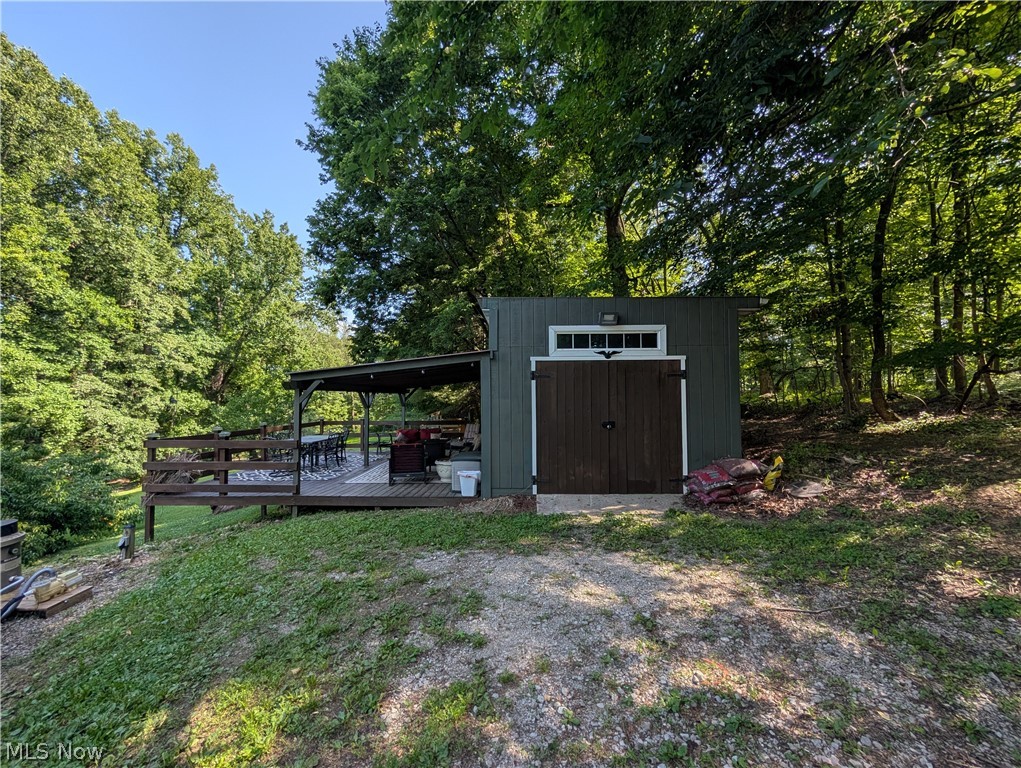 6700 McCaslin Road Nashport, OH 43830 - Photo 4 of 30 Detached outbuilding featuring a covered porch, wood-finish decking, and an additional storage area with double doors and transom windows
