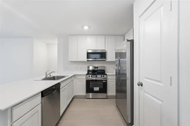 a kitchen with a sink stove and refrigerator