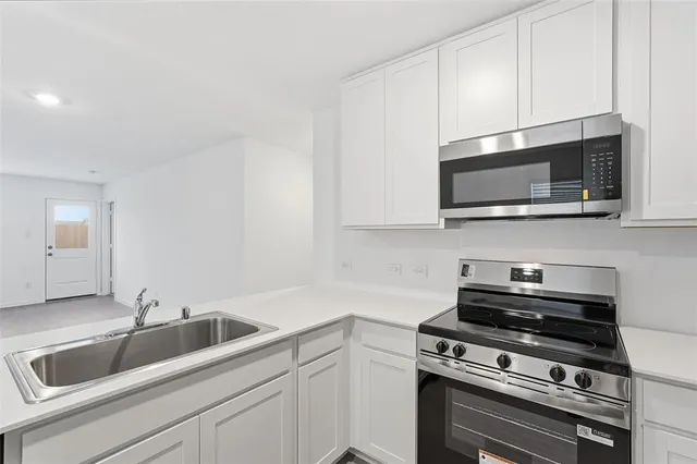 a kitchen with appliances a sink and cabinets
