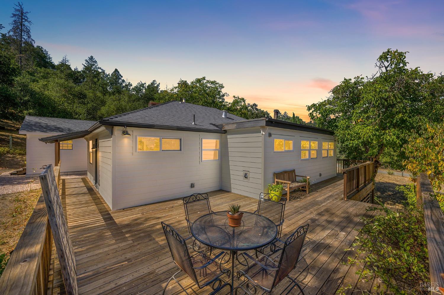 a backyard of a house with wooden floor and outdoor seating