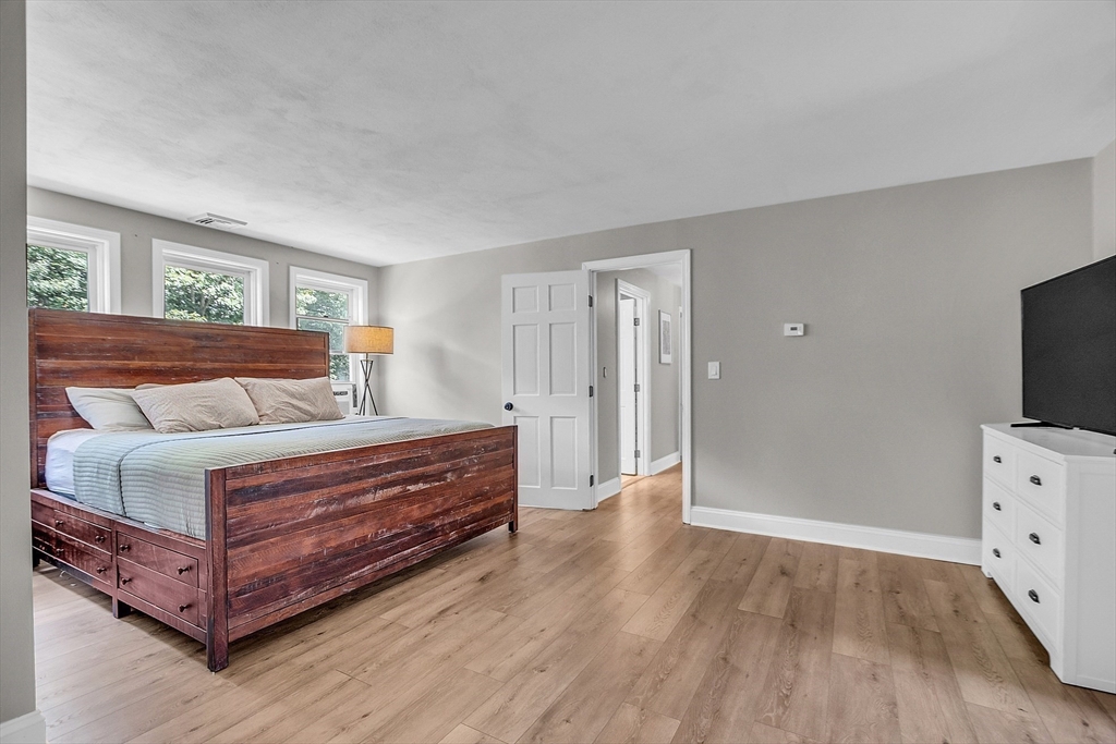 71B South Road Pepperell, MA 01463 - Photo 23 of 42 a spacious bedroom with a bed and wooden floor