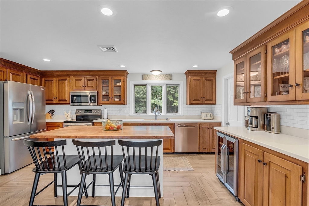 71B South Road Pepperell, MA 01463 - Photo 8 of 42 a kitchen with a table chairs stove refrigerator and cabinets