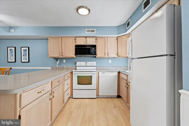 a kitchen with white cabinets and white appliances