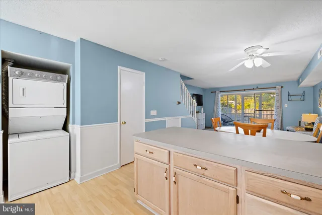 a kitchen with a sink dishwasher and white cabinets with wooden floor
