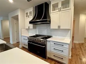 a kitchen with wooden floor and a stove top oven